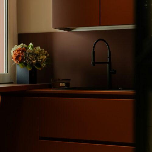 a vase of flowers sitting on a counter next to a window